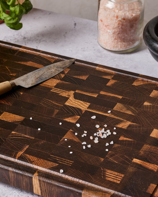 Dark-Oaken-Stirnholzbrett aus Räuchereiche mit Messer und grobem Salz