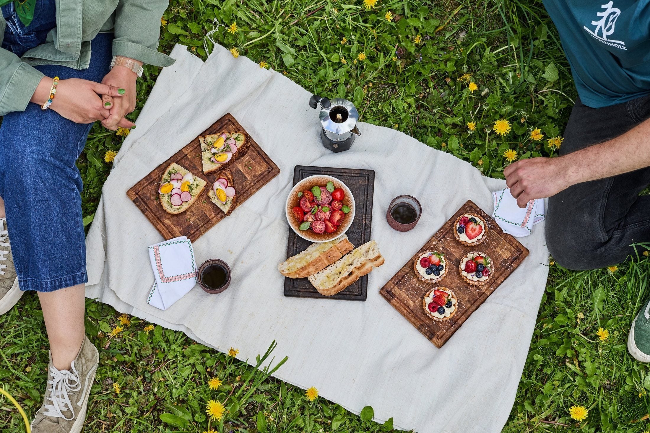 Picknick im Gras mit drei Klingenholz-Brettern als Servierbretter